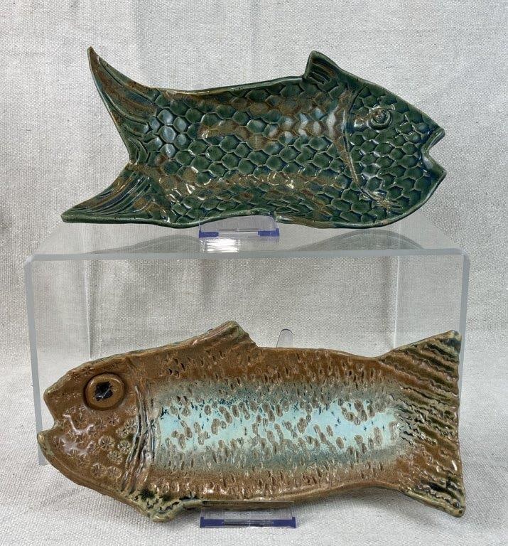 Two Studio Pottery Fish Form Trays: Small trays formed as fish with descriptive impressed and incised textures throughout, finished in rich brown and green glazes. Both bear incised artist signatures on the underside. One measures