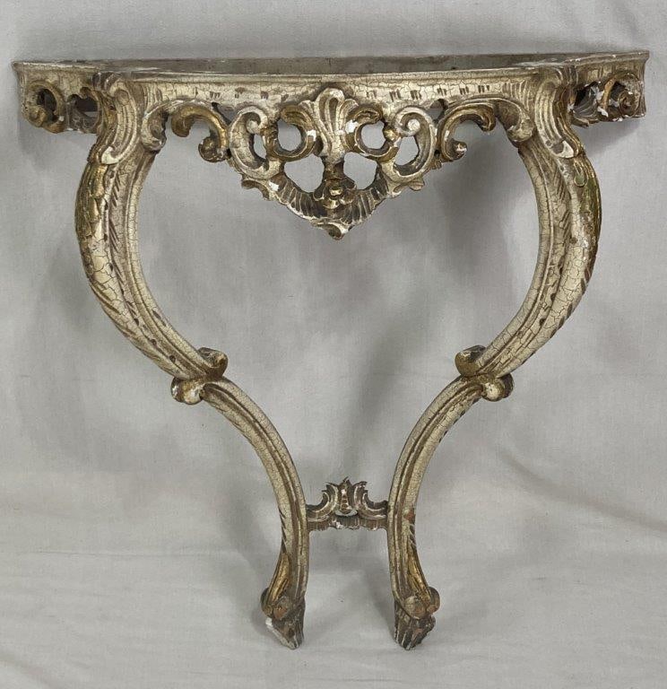 French Louis XV Style Giltwood Console Table: French Louis XV style console table featuring hand-carved giltwood construction with flowing floral ornamentation and sinuous curving lines characteristic of Rococo design. The apron and legs display