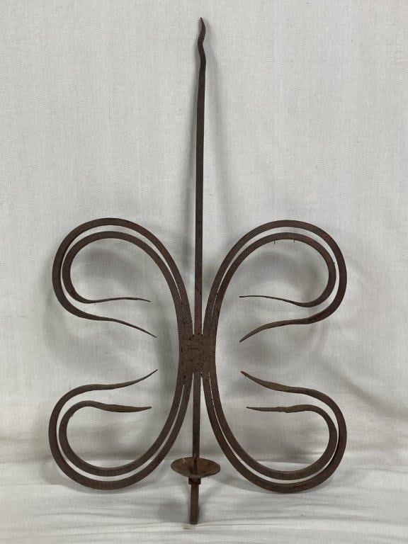 Wrought Iron Wall Sconce: A large decorative wall-mounted candle holder featuring elegant, fluid scrollwork in a vertical orientation. The piece includes a single space for candle placement and is crafted from sturdy wrought