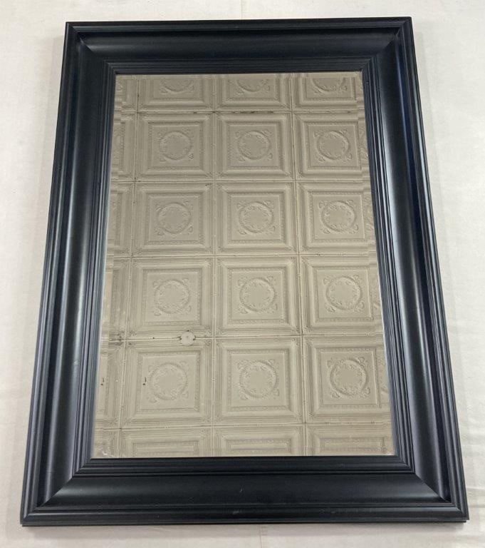 Framed Beveled Mirror: A large wall mirror featuring a sleek, understated frame in a traditional style. The frame houses a high-quality beveled glass pane, offering an elegant and versatile form suitable for various