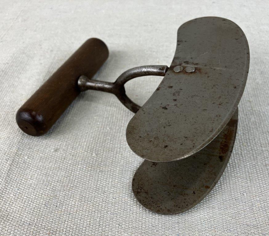 Primitive Double-Blade Food Chopper: Primitive kitchen tool, also known as a mezzaluna, used for chopping food. Features a double blade with a wood handle showing a rich patina. Measures approximately 5 1/8″ H x 5 1/2″ W x