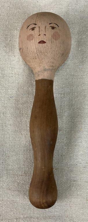 Primitive Folk Art Children's Doll: Handmade wooden doll with simple hand-hewn construction, featuring a curved form and a painted face with primitive features. Likely intended for a child’s play. Measures approximately 8