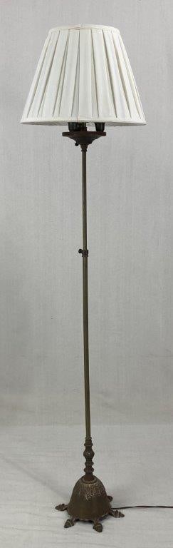 Art Nouveau Floor Lamp: Floor lamp featuring an iron base with decorative flowing and curving elements characteristic of the Art Nouveau aesthetic. The sculptural metalwork reflects the organic lines and elegant movement