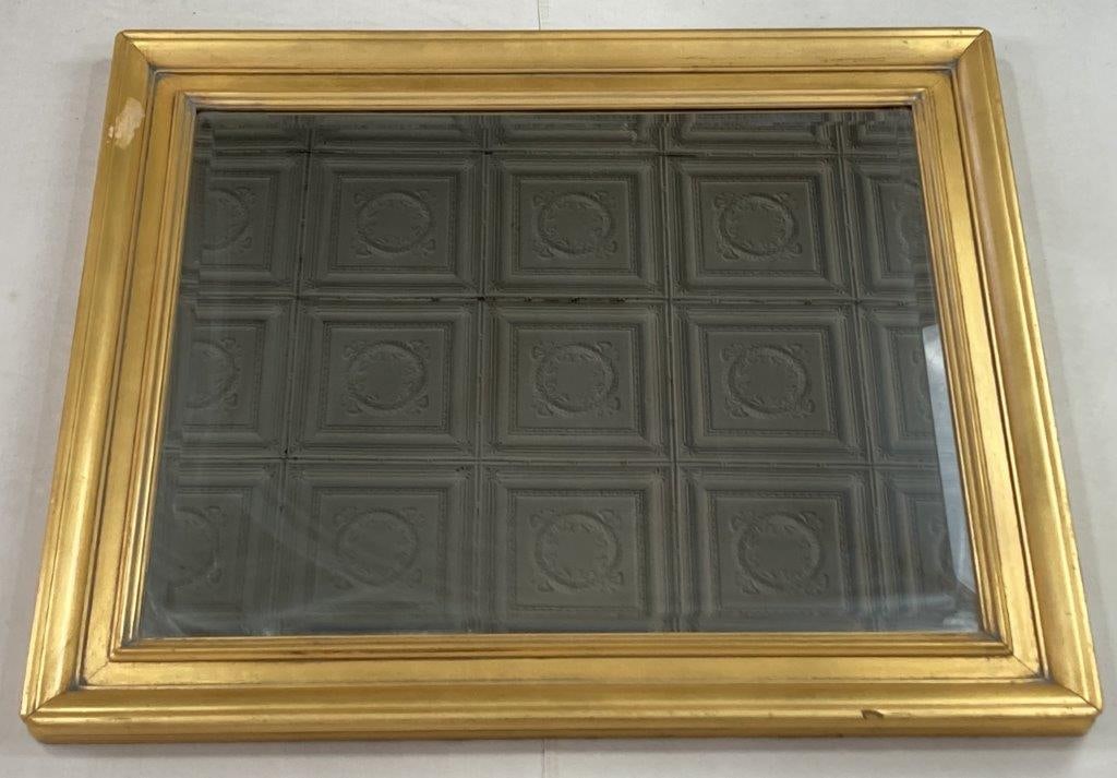 Gilt Frame Beveled Wall Mirror: Wall mirror housed in a gilt frame featuring a distinctive beveled glass mirror plate. The frame displays warm gilt tones that complement the reflective beveled edge of the mirror, creating an