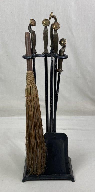 Wrought Iron and Brass Fireplace Tools: A set of hand-wrought iron tools blending functional utility with artisanal decorative appeal. Each tool is topped with an elegant brass handle and a unique, fluidly curving floral motif. The set