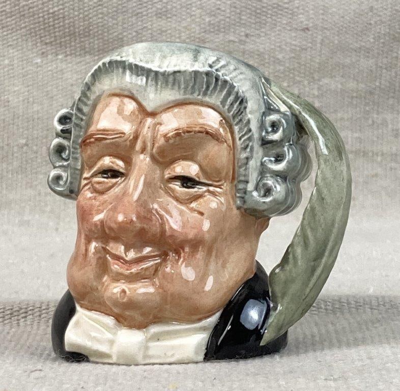 The Lawyer Royal Doulton Toby Jug: A collectible small English character jug featuring the whimsical and expressive features unique to Royal Doulton figures. This miniature ceramic vessel is marked as "The Lawyer" (or alternatively