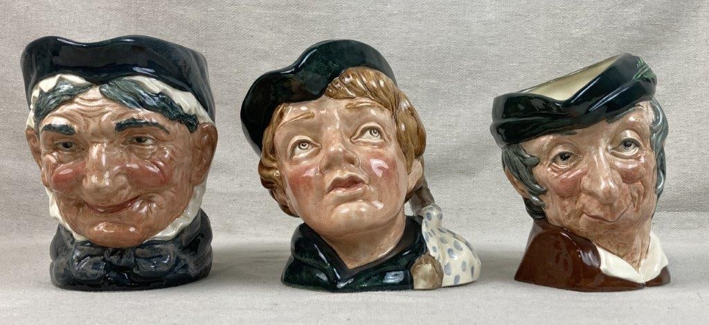 Three Royal Doulton Toby Jugs: A grouping of collectible English character jugs expertly crafted in England. This set includes the figures of Dick Whittington, Simple Simon, and Granny, each showcasing the whimsical, expressive