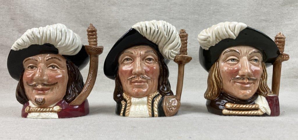 Three Royal Doulton "Three Musketeers" Toby Jugs: A complete set of collectible small English character jugs depicting the famous literary trio: Porthos, Aramis, and Athos. Each piece is expertly crafted in England, featuring the rich hand-painted