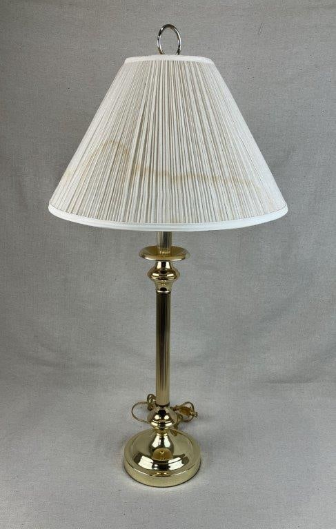 Brass Table Lamp: An elegant lighting fixture featuring a classic fluted brass column that rises from a tiered base to provide a sophisticated, architectural silhouette. The polished brass construction reflects a