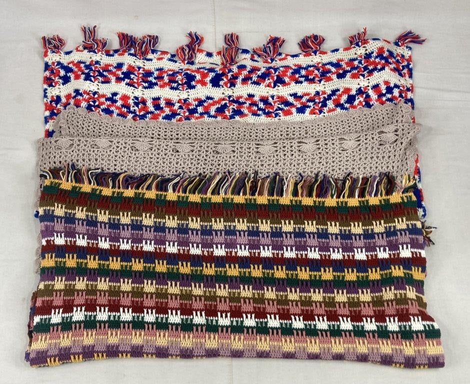 Three Crocheted Afghans: A cozy and hand-crafted trio of traditional blankets showcasing a range of artisanal techniques and color palettes, including two vibrant, multi-tonal pieces that offer a bold pop of color and one