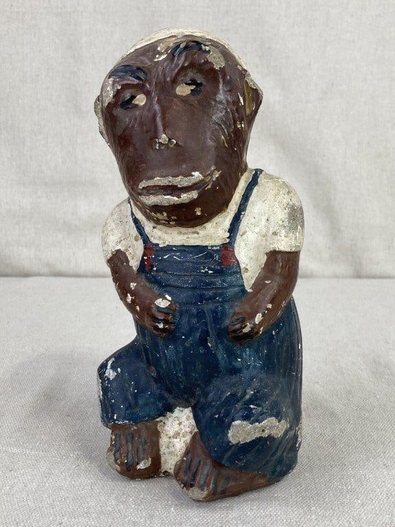 Polychromed Folk Art Monkey Figure: This whimsical folk art piece is crafted from durable cast cement and depicts an anthropomorphic monkey standing in a playful, human-like pose. The figure is hand-painted in a classic palette, featuri
