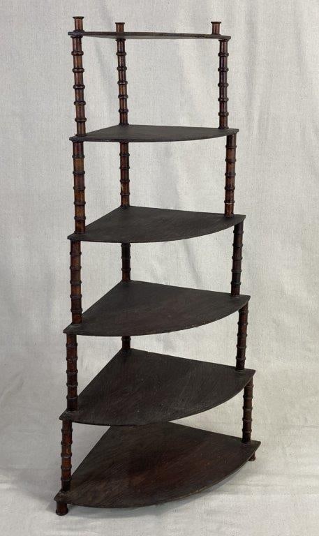 Folk Art Spool Corner Shelf: A graduated six-tier design of triangular shelves supported by repurposed wooden thread spools. Finished in a dark tone with a heavily worn, authentic patina. It measures approximately 48 1/4'' H x