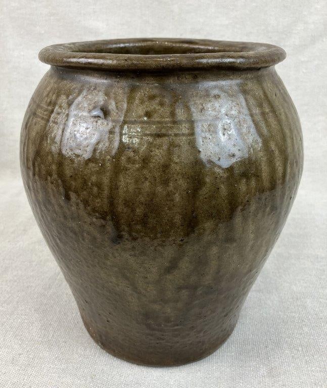 Southern Alkaline Glazed Stoneware Pot: A significant example of regional ceramic heritage featuring a robust, rounded form coated in a rich, olive-green runny alkaline glaze characteristic of the historic potteries of the American South,