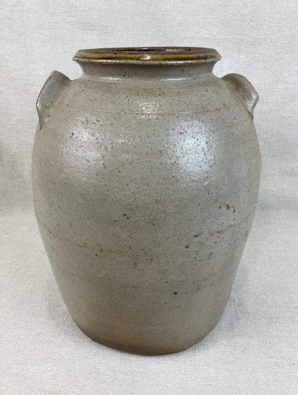 Salt Glaze Stoneware Storage Jar: This vessel features a traditional ovoid form with applied lug handles and a single incised band at the shoulder. The exterior is finished in a salt glaze, while the interior is coated in a dark