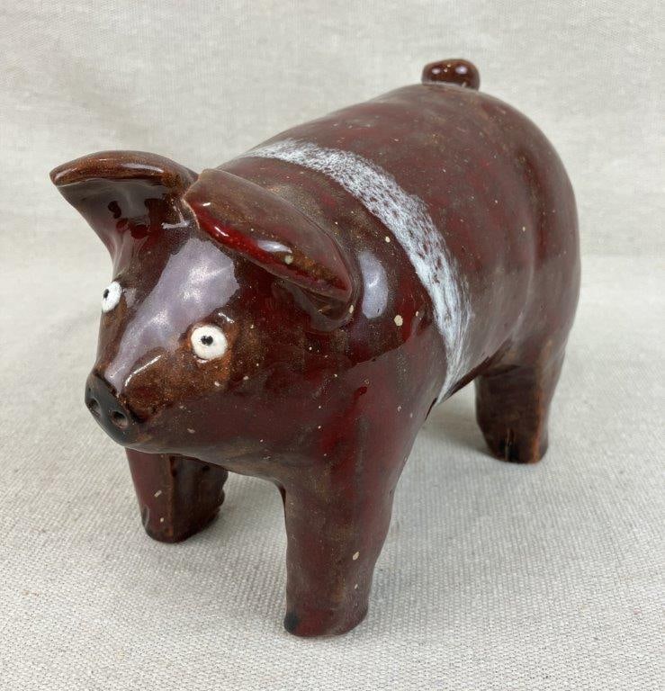 Wilson Pottery Pig: This piece features a distinctive form finished in a red and white glaze. It measures approximately 5 1/4" H x 7" W x 4" D. The condition includes one break to the tail.