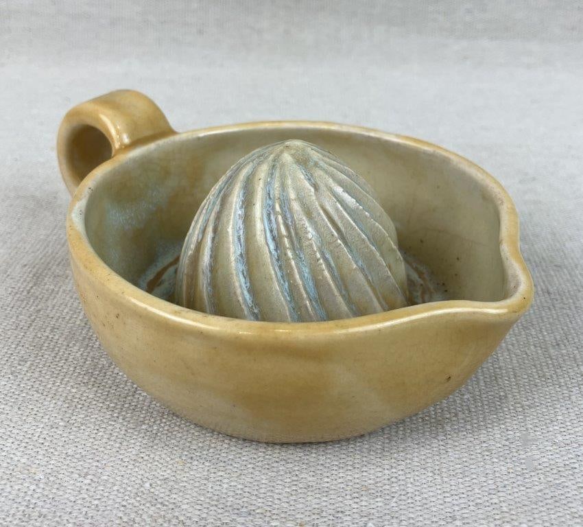 Studio Pottery Lemon Juicer: This functional piece features an applied handle and is finished in a soft yellow glaze. It measures approximately 2" H x 6 1/4" W x 4 5/8" D. The juicer remains in good condition. 