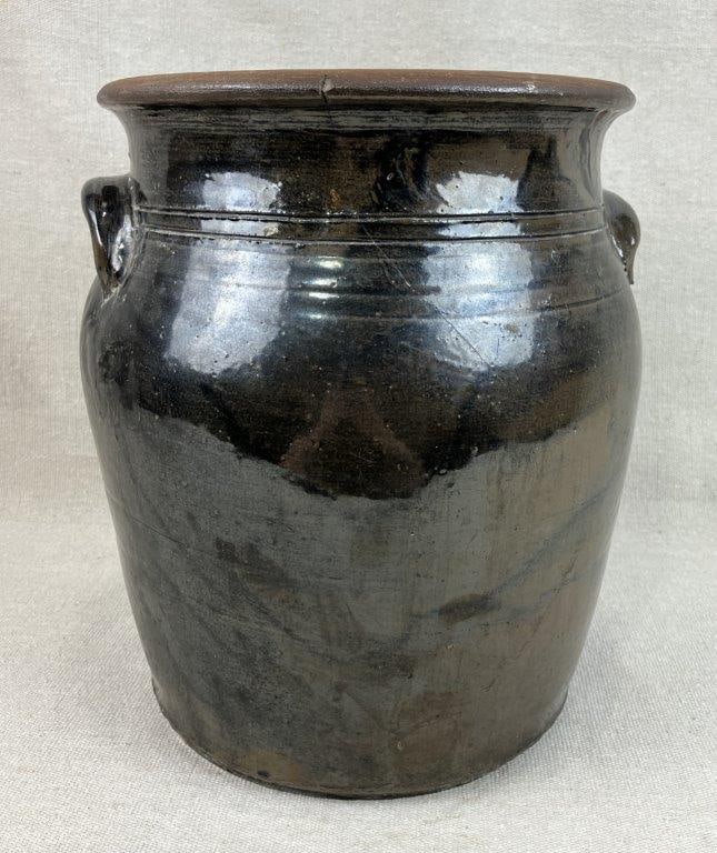 Stoneware Glazed Crock: This crock features a defined lip, two applied lug handles, and decorative incised rings along the shoulder. It is finished in a rich, dark earthy brown glaze and measures approximately 10 3/4" H x 8