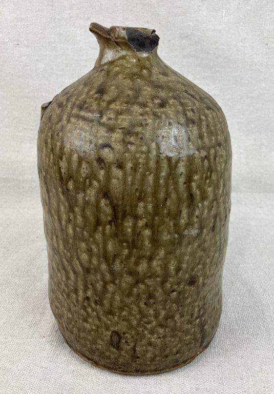 Georgia Alkaline Glaze Stoneware Jug: This cylindrical vessel is finished in a rich, runny green alkaline glaze characteristic of the region. It originally featured an applied handle and measures approximately 10" H x 5 1/4" in diameter.