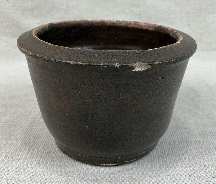 Glazed Stoneware Bowl: This versatile utilitarian bowl features a slightly flared form finished in a deep, rich brown glaze that provides a warm and lustrous appearance. Measuring approximately 4" H x 6" in diameter, the