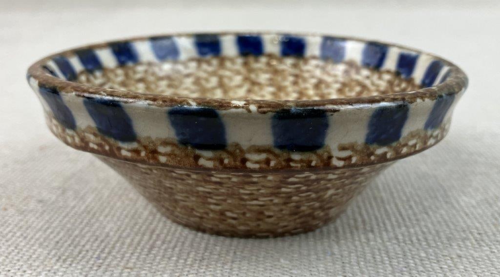 Small German Folk Pottery Bowl: Petite German pottery bowl featuring a brown patterned glaze accented with cobalt striping along the lip. The form reflects traditional mountain pottery styles with simple decorative banding. Marked