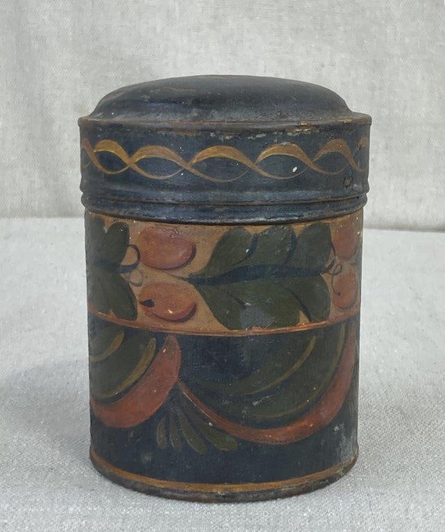 19th Century Toleware Canister: 19th-century toleware canister featuring a classic cylindrical body and a functional hinged lid. The piece is adorned with hand-painted foliage motifs and elegant swirling lines along the rim and the
