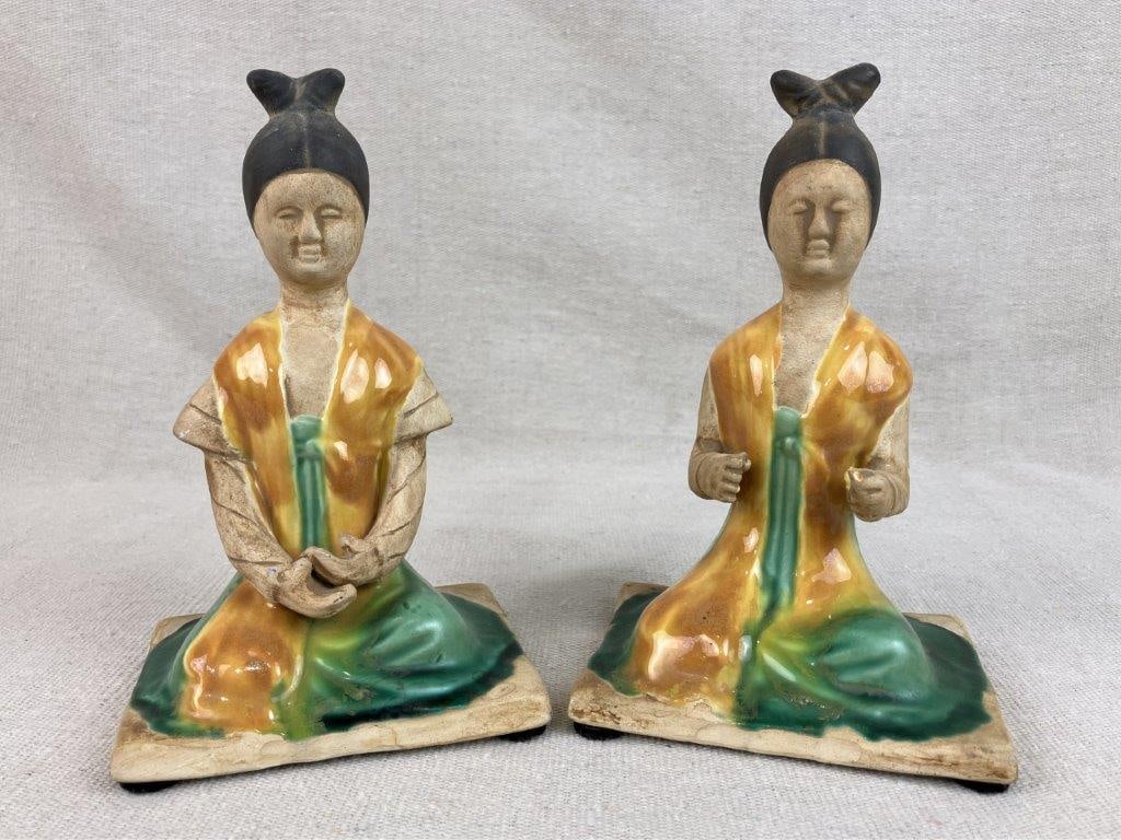 Pair of Chinese Glazed Pottery Seated Figurines: Pair of Chinese pottery figurines in seated forms, finished in a vibrant green and yellow glaze. The figures display traditional styling with balanced proportions and decorative surface treatment typi