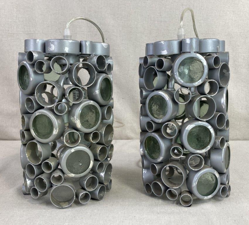 Modernist Pendant Lamps: This striking pair of pendant lamps features a bold modernist design, each constructed from a hand-crafted steel frame of welded rings in varying sizes. The geometric composition is uniquely accented