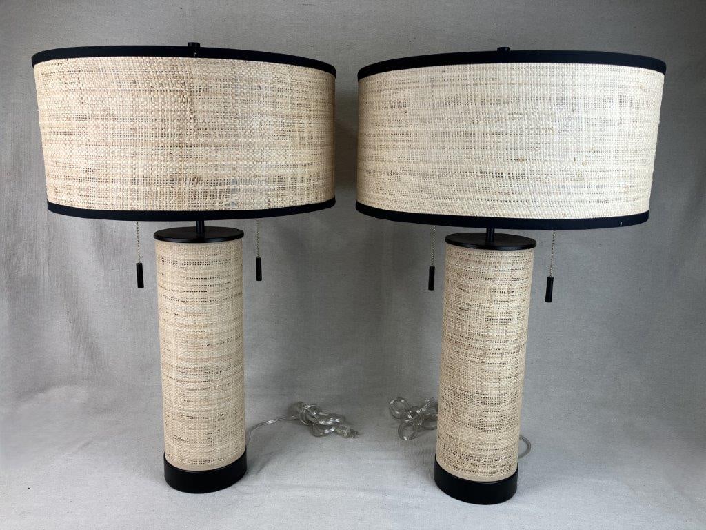 Pair of Rattan Table Lamps: Pair of table lamps featuring cylindrical rattan bases with matching wide drum form shades, fully decorated in woven rattan for a cohesive natural aesthetic. The design reflects casual, coastal or