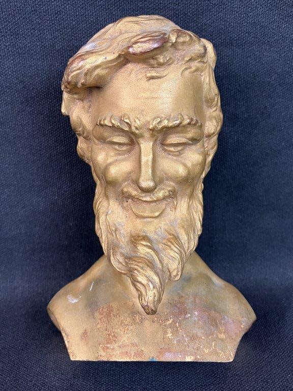 Cast Male Bust Sculpture: Cast sculpture depicting a bearded male bust with a warm gilt finish, featuring expressive, finely modeled facial features and a cheerful countenance. The piece displays strong sculptural detail with