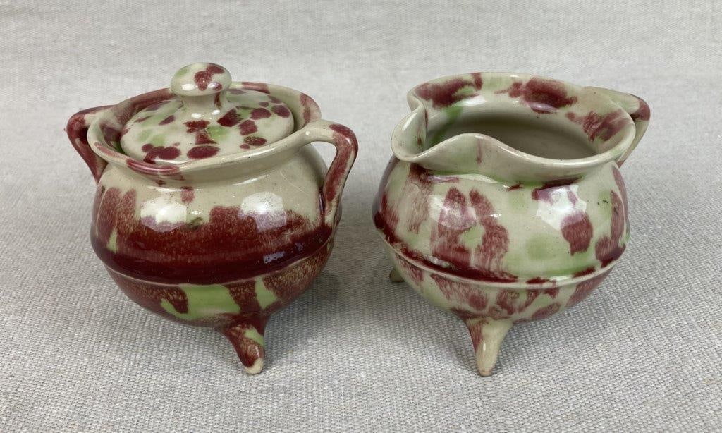 W.J. Gordy Art Pottery Sugar and Creamer Set: Executed in an unusual variegated glaze of greenish-yellow and purple hues, this two-piece set showcases the distinctive style of Georgia potter W.J. Gordy. The sugar bowl features the maker's impress