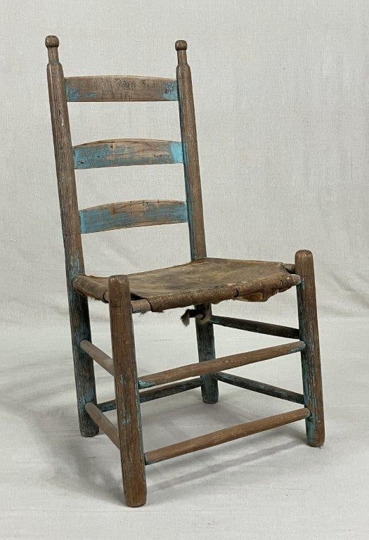 Blue Country Ladder Back Chair: Features a bright blue old surface with turned posts and shaped splats. Finished with a cowhide seat. Measures approx. 35'' H x 18 1/2'' W x 14'' D, with a floor-to-seat height of 15''. Good condition