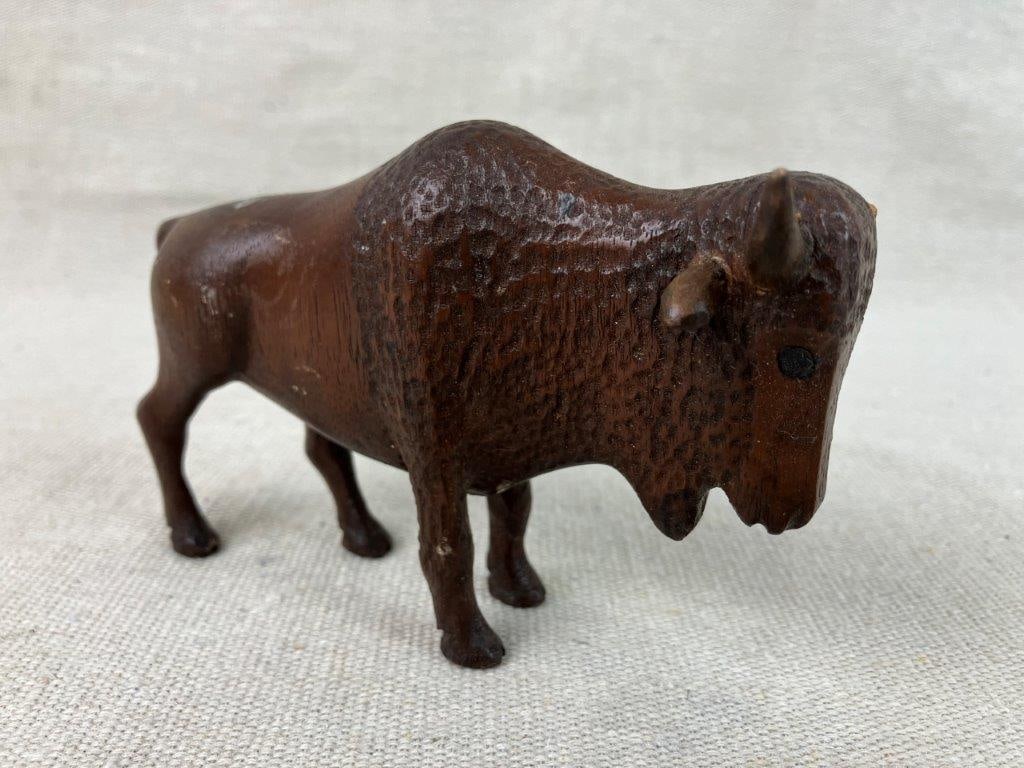 Folk Art Carved Buffalo: Small hand-carved buffalo figurine in mahogany, displaying strong folk artistry with a compact, well-defined form. The rich wood tone enhances the sculptural presence. Measures approximately 3″ 