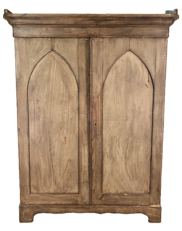 19th Century Southern Wardrobe: Southern wardrobe in simulated mahogany over yellow pine, likely Georgia origin, featuring Gothic-style arched double doors, a defined cornice, and a shaped apron with bracket feet, with a rich,