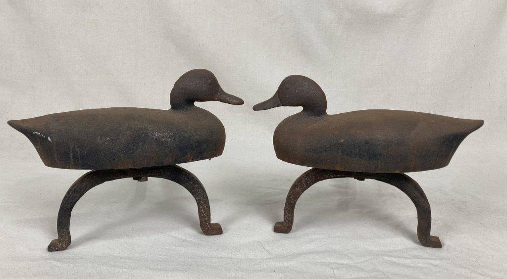 Cast Iron Duck Andirons: Pair of cast iron andirons featuring traditional duck decoy forms to the fronts, with robust construction suited for hearth use. One measures approximately 11 1/4â€³ H x 14