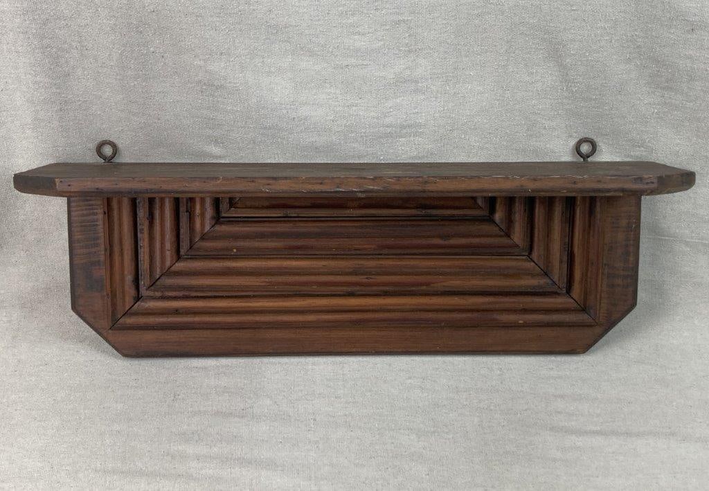 Country Wall Shelf: Wall-mounted shelf composed of layered and stacked molding, crafted in pine with a rich surface and deep patina. Measures approximately 23 7/8″ H x 8 1/4″ W x 7 1/2″ D. General