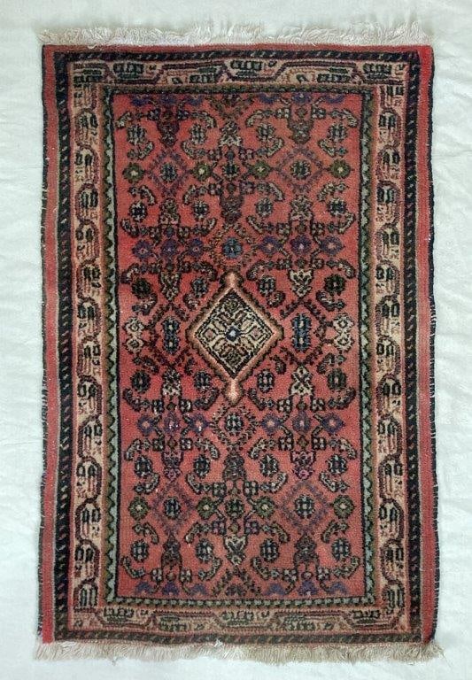 Hamadan Persian Rug: This Hamadan Persian rug is a striking example of regional craftsmanship, featuring a prominent central stepped diamond medallion anchored within a field of intricate floral motifs. The vibrant red