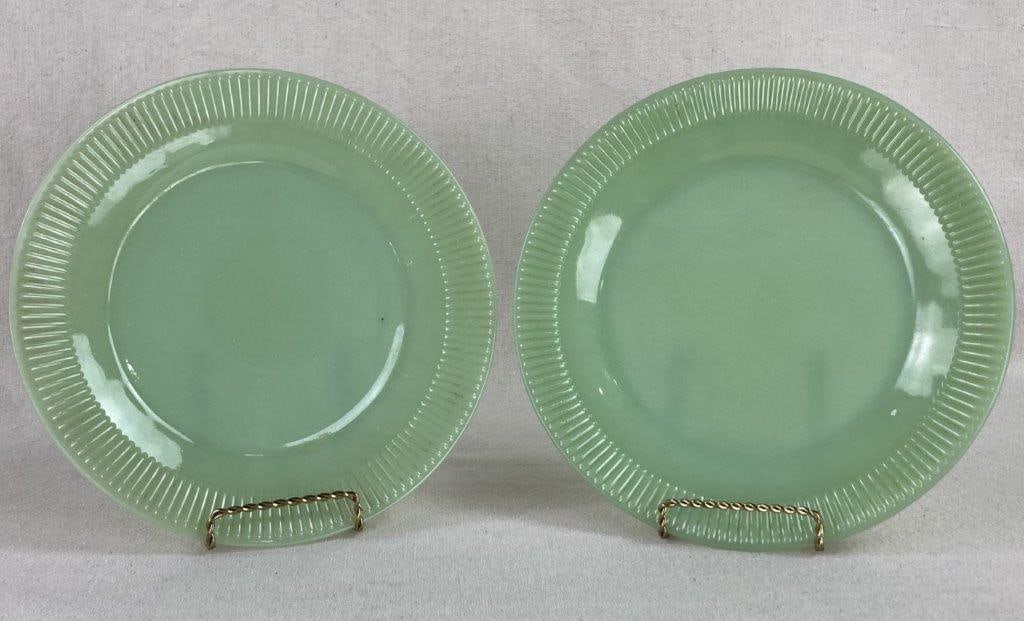 Two Jadeite Plates: This charming duo of jadeite glass plates captures the quintessential mid-century kitchen aesthetic with its signature opaque green hue. Each plate features a decorative ribbed border encircling a