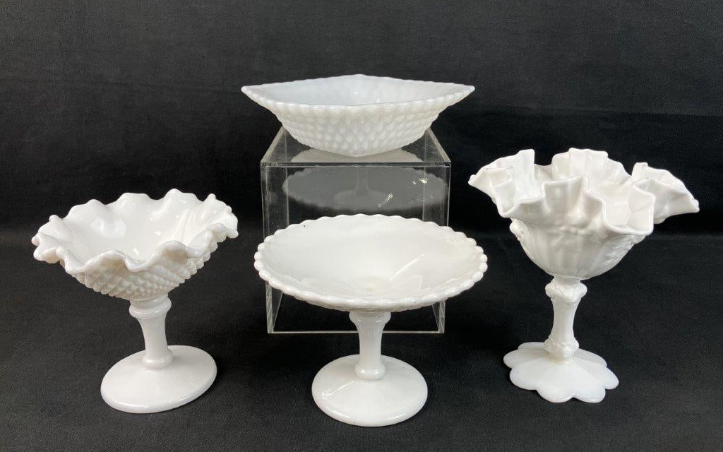 Four Pieces of Milk Glass Dishes: Group of four milk glass dishes, including hobnail and relief-pattern examples, primarily candy dish forms. One measures approximately 6 5/8â€³ H x 6 1/4â€³ in