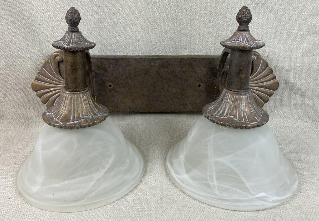 Vanity Light Fixture: Brushed metal vanity light fixture in rich gilt tones, fitted with frosted glass shades in a classic form. Measures approximately 10â€³ H x 18â€³ W x