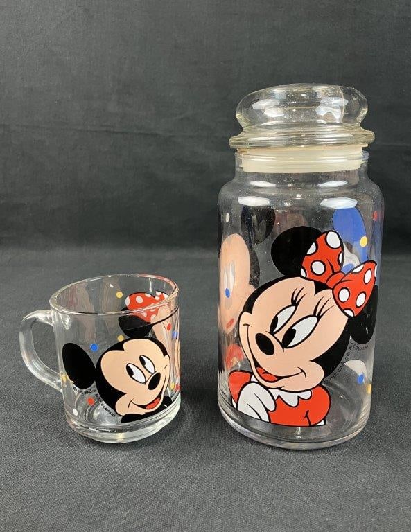 Disney Mickey Mouse Childrenâ€™s Mug and Cookie Jar: Grouping including a lidded canister cookie jar and matching mug featuring Mickey Mouse, Minnie Mouse, and Donald Duck, produced in glass by Anchor Hocking. The canister measures approximately 8
