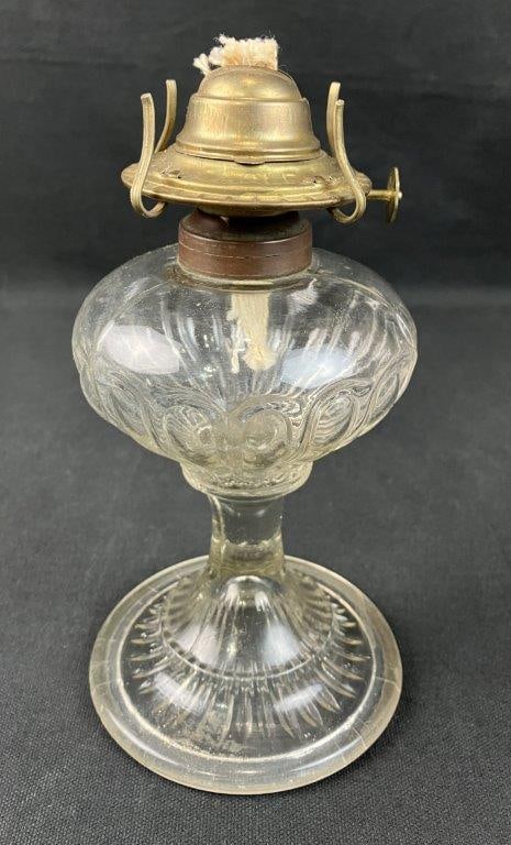 Pressed Glass Oil Lamp: Pressed glass oil lamp with pedestal form and vintage character, fitted with a brass burner. Measures approximately 8 1/4â€³ H x 4â€³ in diameter. Good condition with m