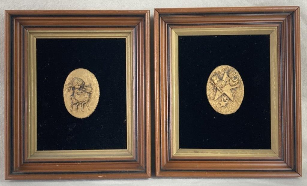 Framed Decorative Wall Plaques: A pair of decorative wall plaques featuring gold-tone oval reliefs set against rich black velvet backgrounds. One plaque depicts a whimsical scene of a little girl riding a farm animal, while the