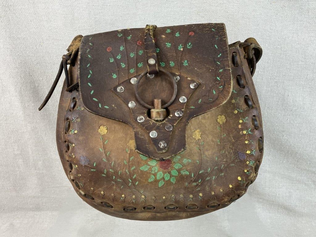Western Hand-Tooled Leather Saddle Bag Purse: Hand-tooled leather saddle bag purse with Western styling, featuring braided leather details, hand-painted accents, silvertone rivets, and a shoulder strap. Measures approximately