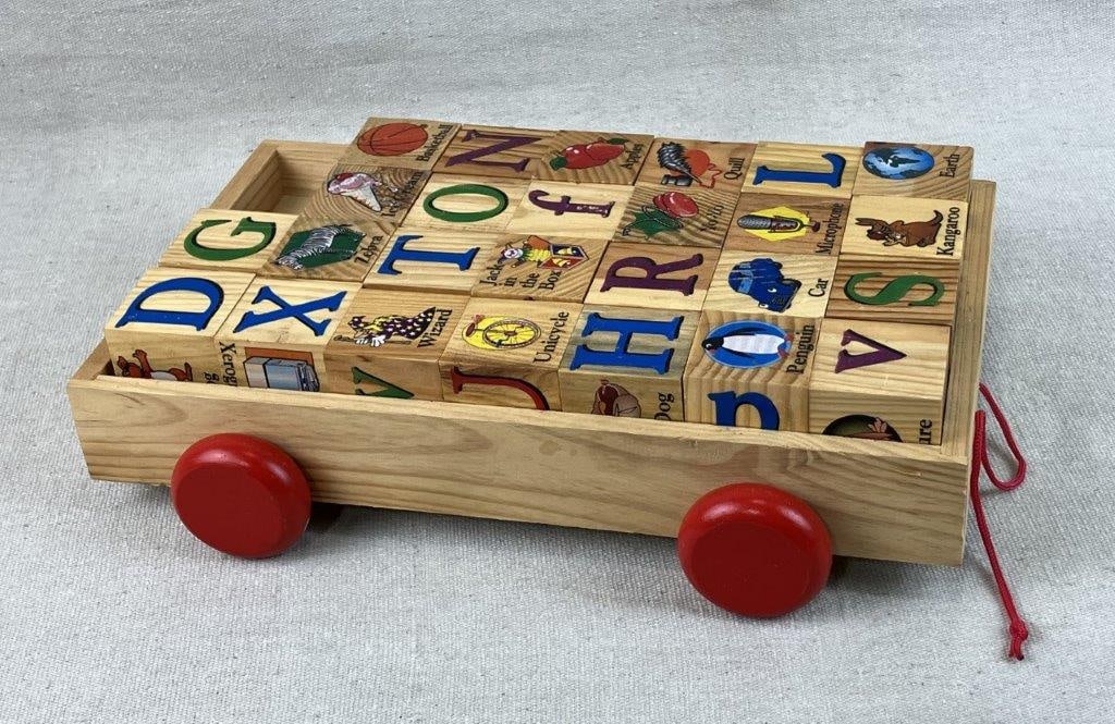 Set of Childrenâ€™s Alphabet Blocks with Pull Cart: Vintage set of wooden alphabet blocks featuring letters paired with coordinating animals or objects, accompanied by a wooden pull-toy cart. The cart measures approximately 2 1/2â€³ H