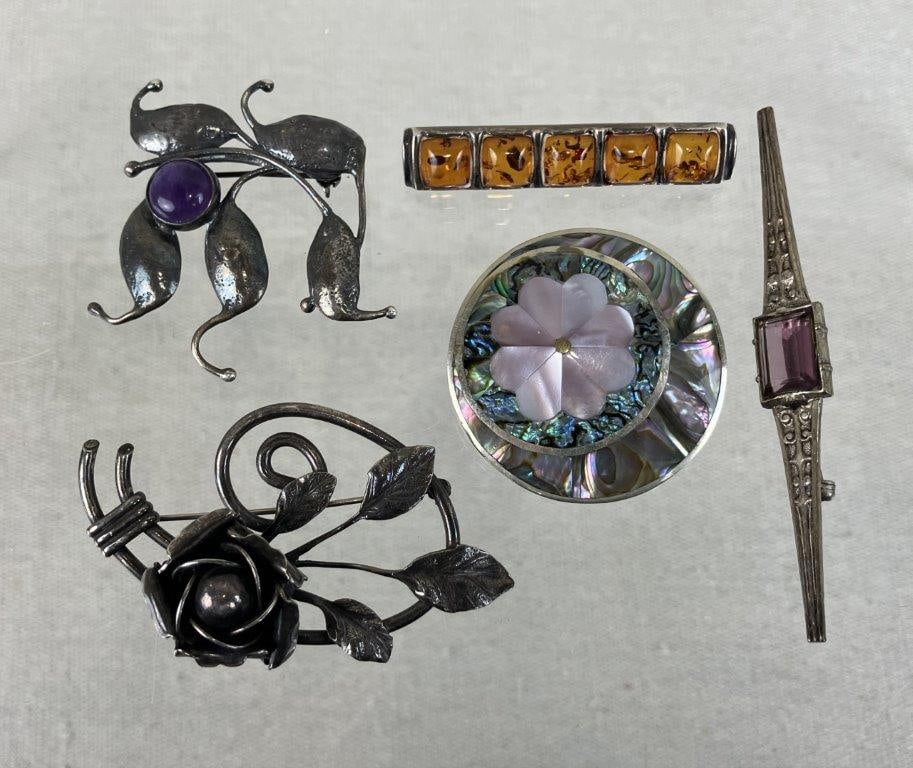Assortment of Vintage Brooches: A collection of five vintage brooches showcasing detailed metalwork and vibrant, natural accents. The assortment features a pendant brooch stamped "Alpaca Mexico" crafted from alpaca metal with an