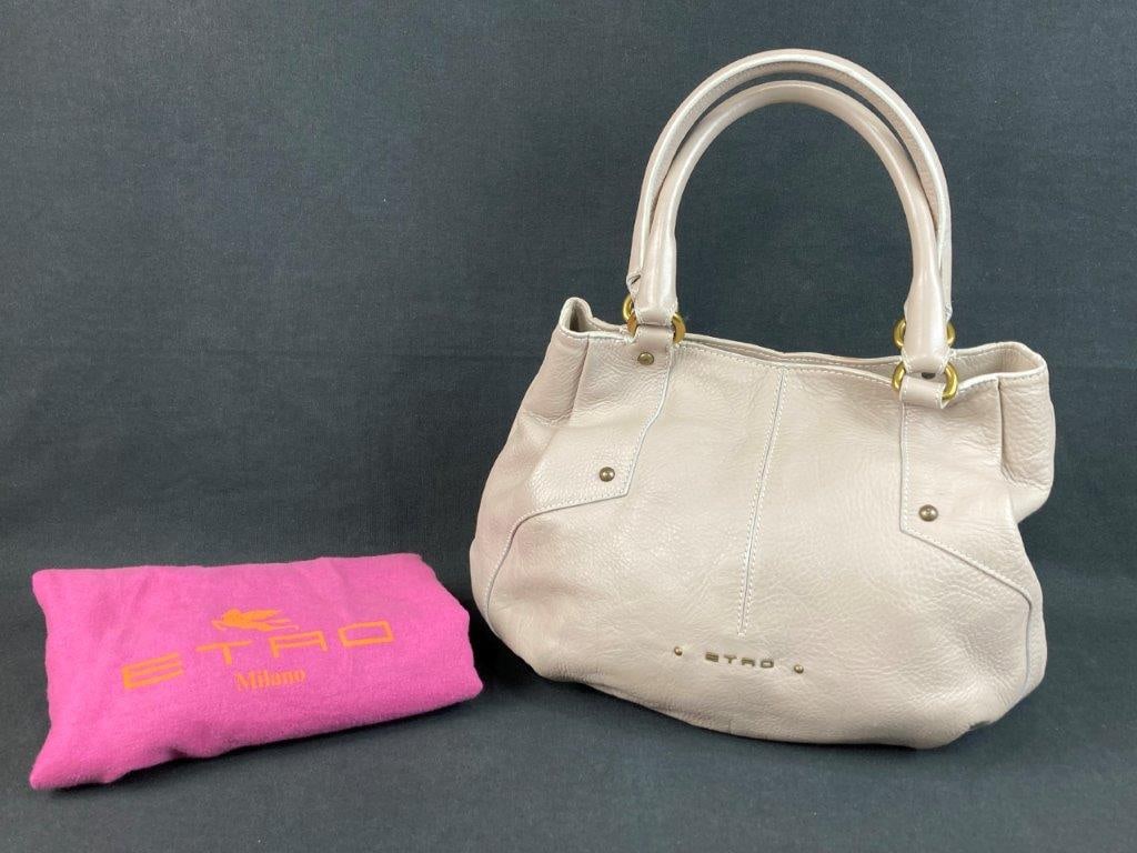 Etro Leather Purse: This Etro purse is crafted from cream-colored pebbled calfskin leather and features gold-tone top handle rings and Etro gold-tone block lettering on the front. The interior is designed with two