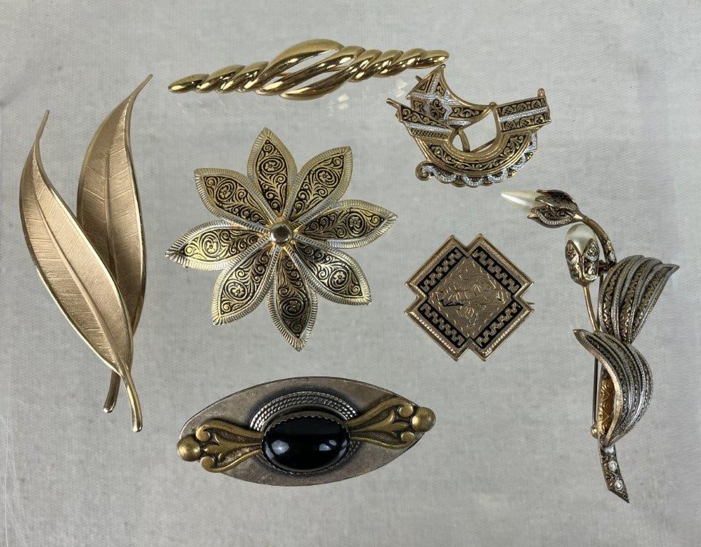 Vintage Gold-Tone Brooches Including Napier and Spanish Styles: A beautiful seven-piece assortment of vintage costume brooches highlighted by a standout gold-tone Napier brooch with a twisted, horizontally oriented design, a Primex piece, a twisting brooch