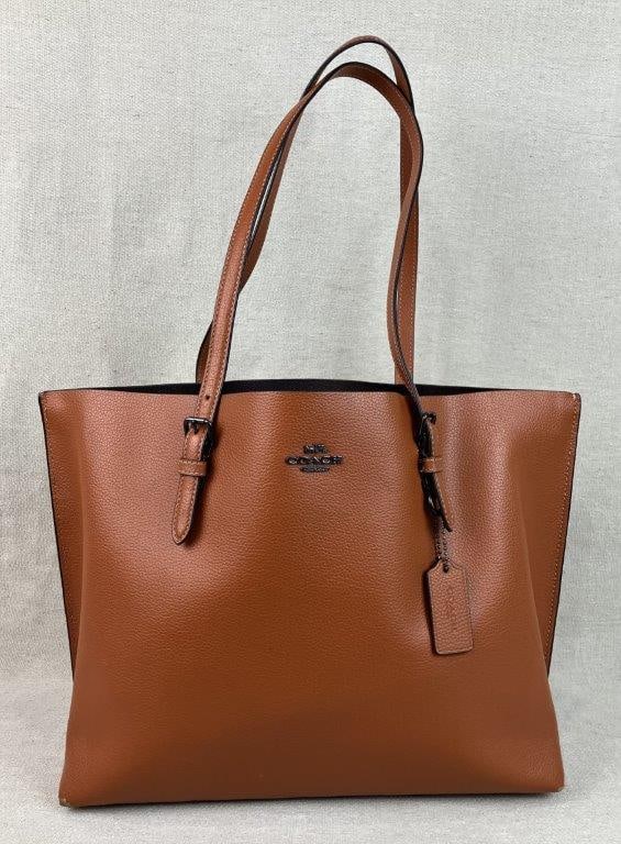 Coach Mollie 1671 Tote Bag: A sophisticated "Mollie" tote by Coach (Model 1671), featuring a classic brown leather exterior paired with adjustable shoulder straps for versatile wear. The bag's interior offers a striking