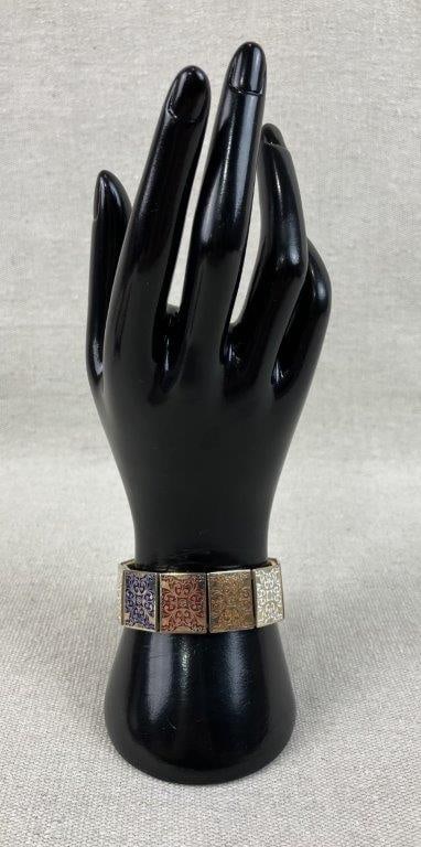 Renaissance Revival Enameled Filigree Bracelet: This elegant Renaissance Revival bracelet features a series of decorative filigree stations and panels accented with vibrant enamel detailing in a rich palette of blue, red, white, and gold-tones.