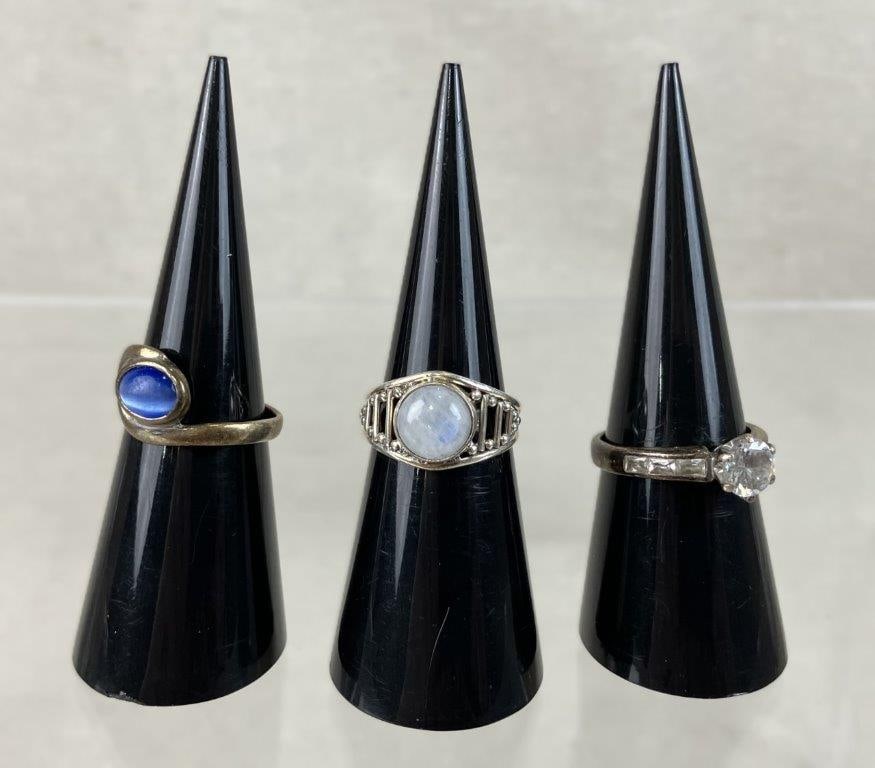 Three Sterling Silver Rings: This collection of three sterling silver rings features a variety of unique designs, including one ring centered by a light labradorite gemstone on a reticulated band in an approximate size 5, another